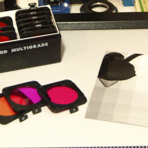 workspace showing various colored filters used in the process of split grade printing in a photo darkroom